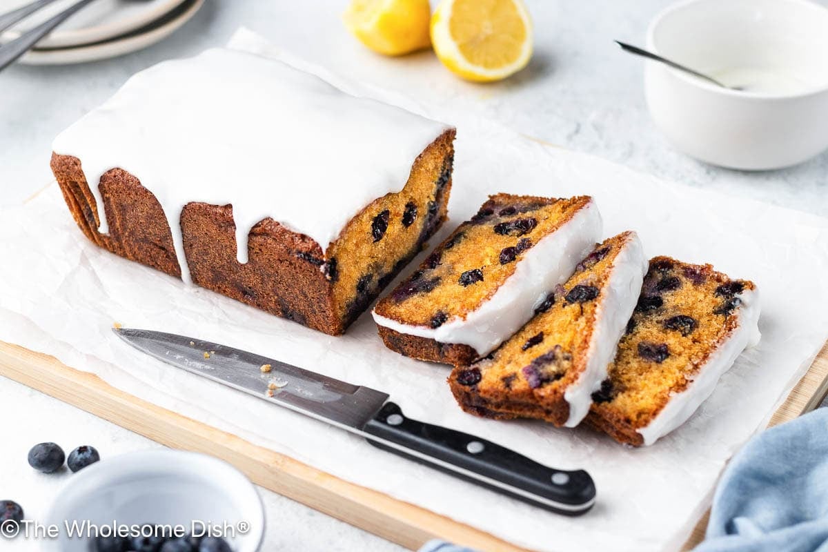 Sliced lemon blueberry loaf on a cutting board.