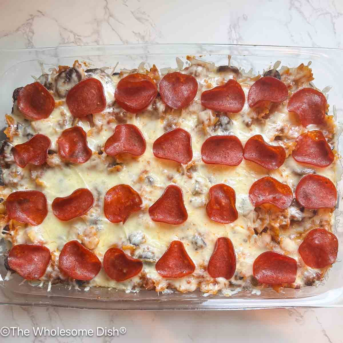Glass baking dish full of Supreme pizza pasta bake.