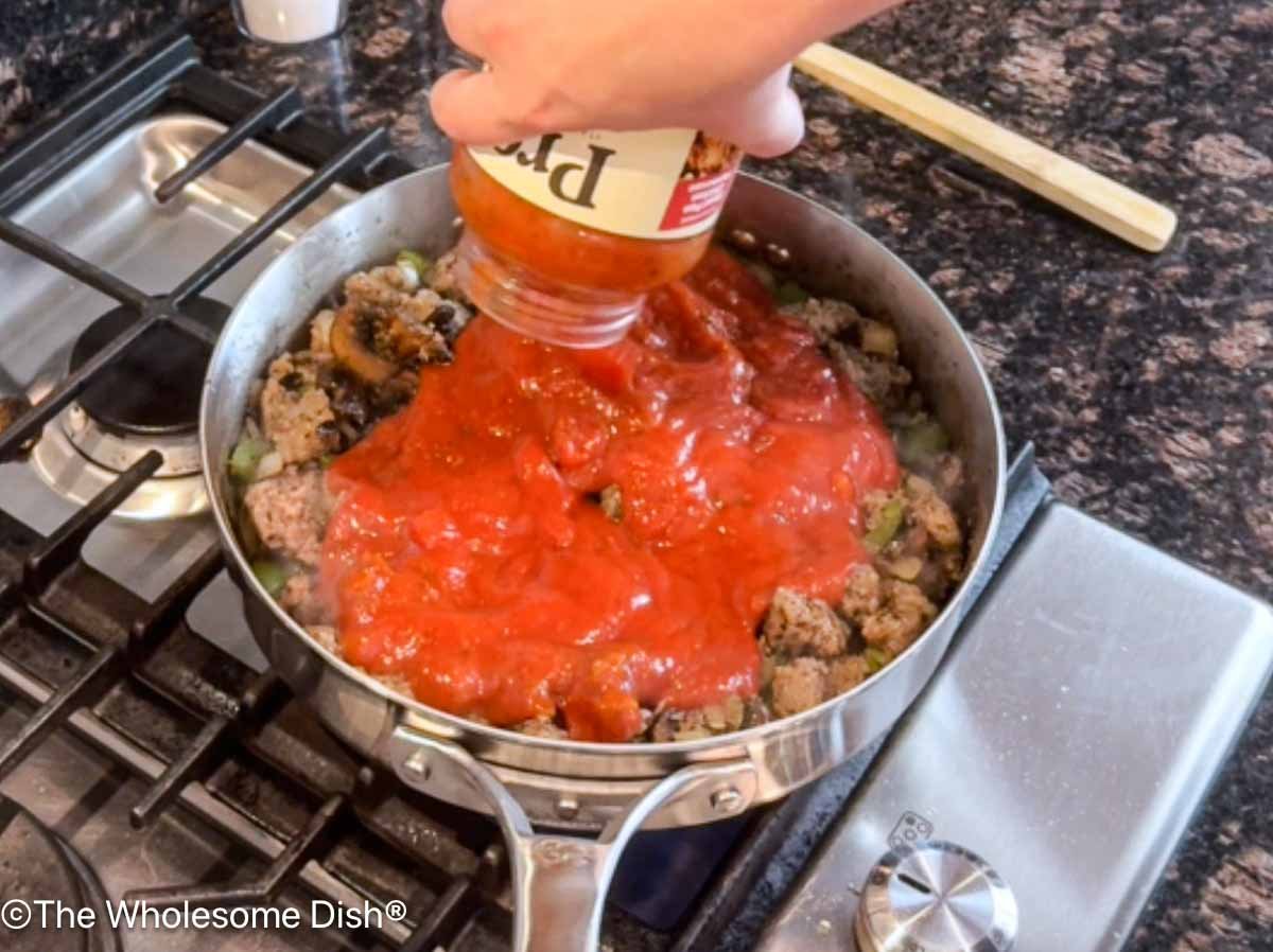 Pasta sauce being added to the skillet.