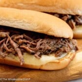 A french dip sandwich on a cutting board.