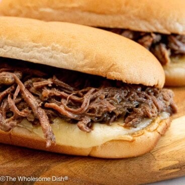 A french dip sandwich on a cutting board.