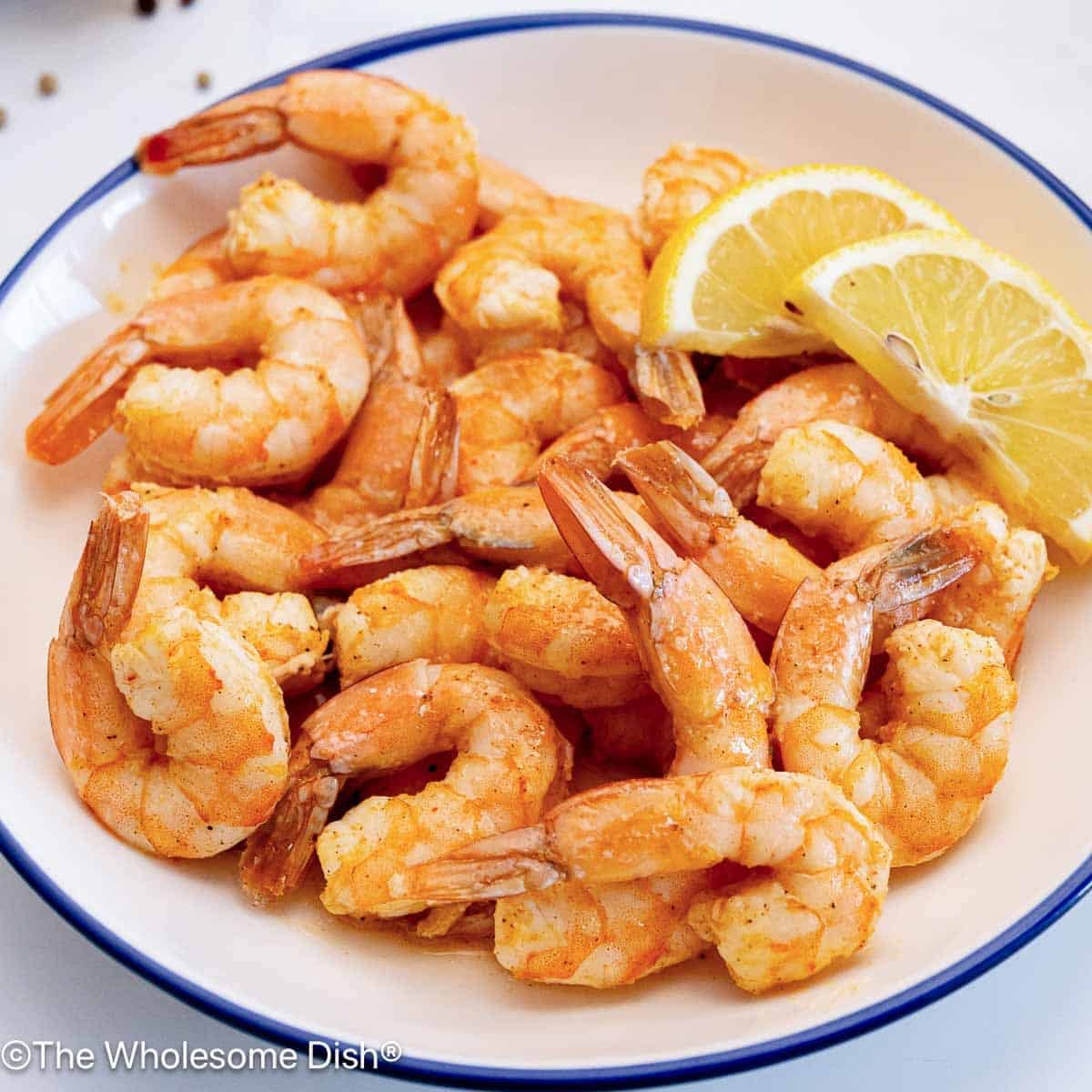 Bowl full of baked shrimp.